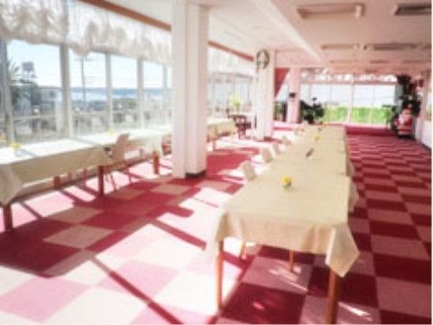 白いクロスが敷かれた机と椅子が並んでいて、壁一面が窓になっている明るい食堂