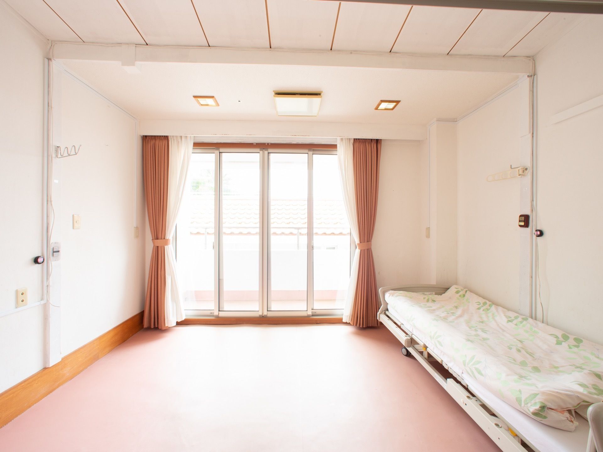 間口の広い窓が設置され、ベランダが完備された居室である。広々とした居室内には、介護用ベッドが置かれている。