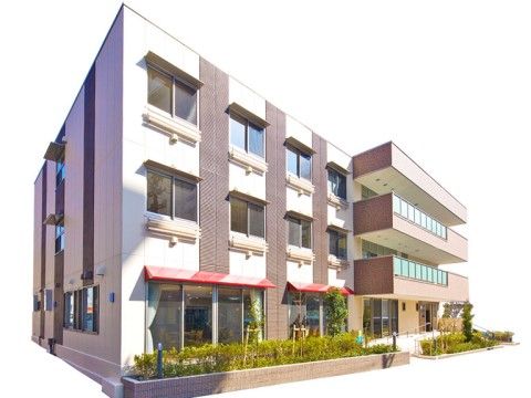 「近鉄ウェルスマイル八戸ノ里」の外観。一階に大きな窓のあるモダンな建物です。
