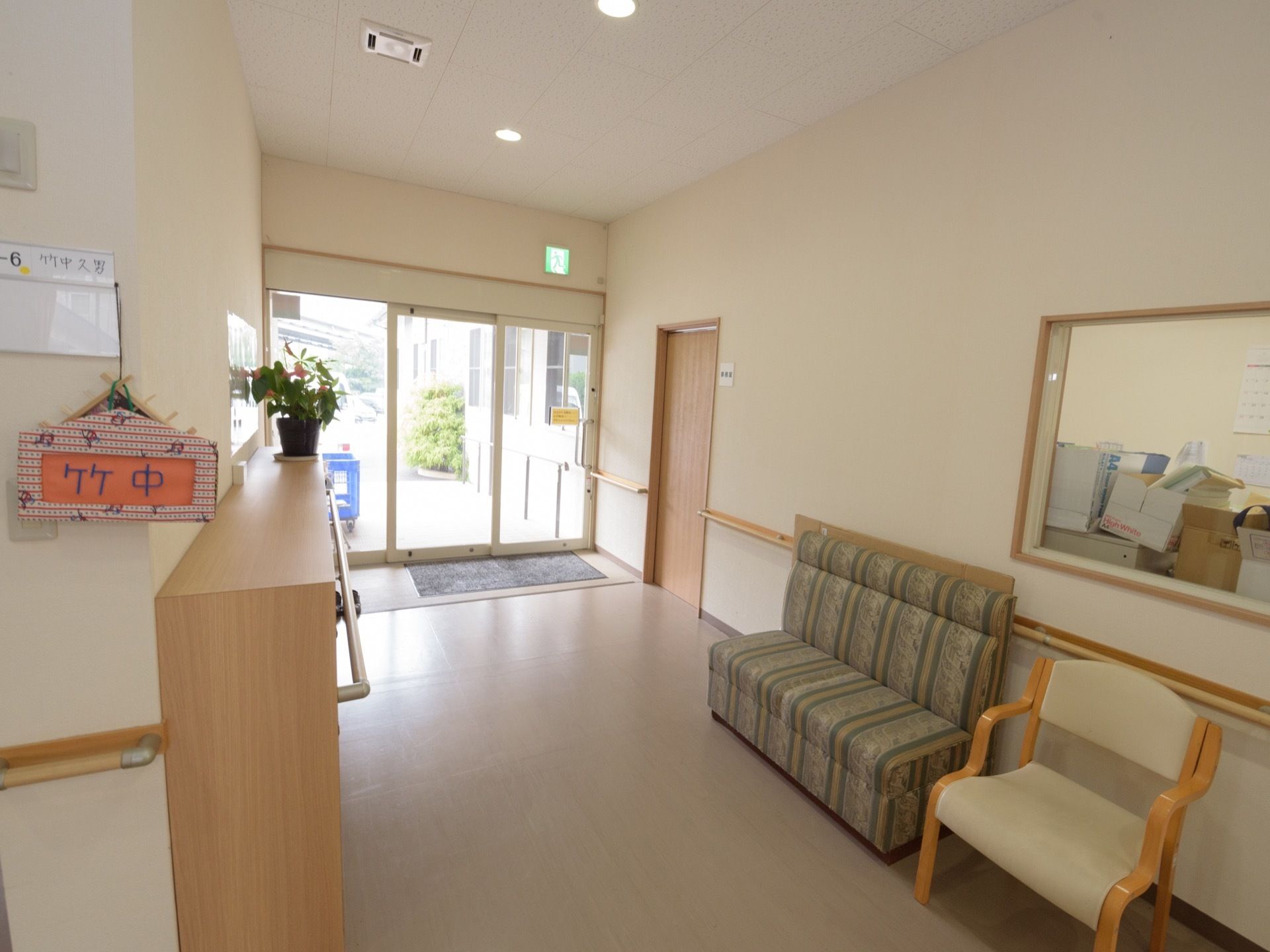玄関内部の床はフラットで、壁には両側に手すりを設置している。前面には椅子を置いて休憩スペースを設けている。