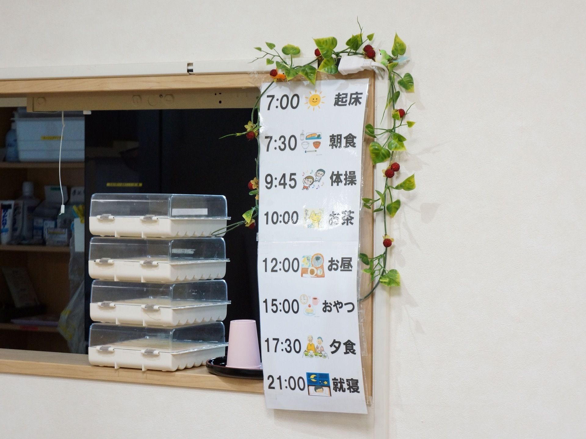 共有スペースに貼られた掲示物。起床から体操、各食事やおやつの時間、就寝までの１日のスケジュールが書かれている。