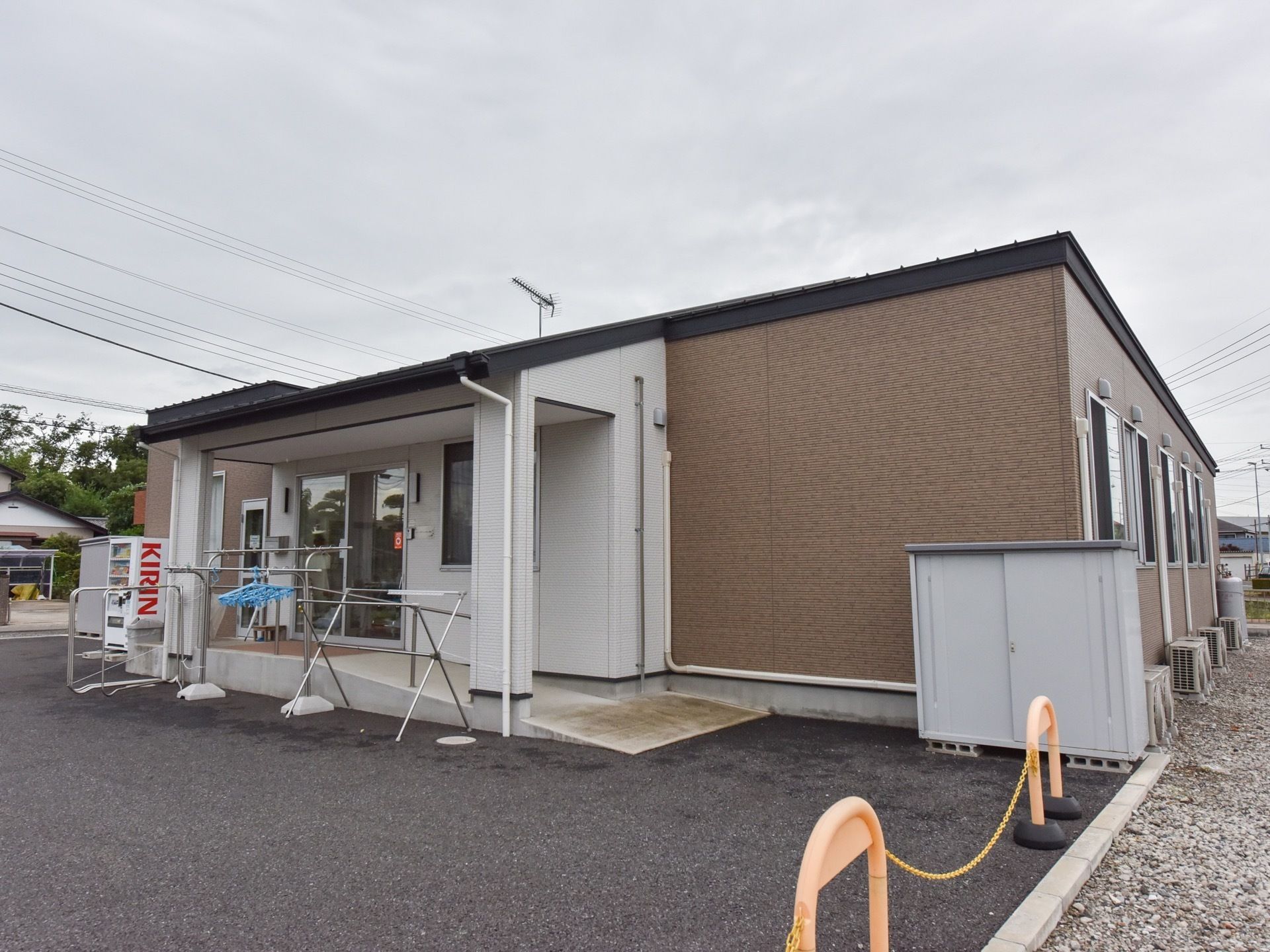 平屋建てのしゃれた建物外観。落ち着いた色の外壁で周辺の環境ともマッチしている。玄関へもスロープ付きで安心である。