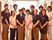 ４名の男性と８名の女性の12名のスタッフが前と後ろに並んで立っている。８人の男女が紺色のポロシャツと茶色のパンツを着用している。