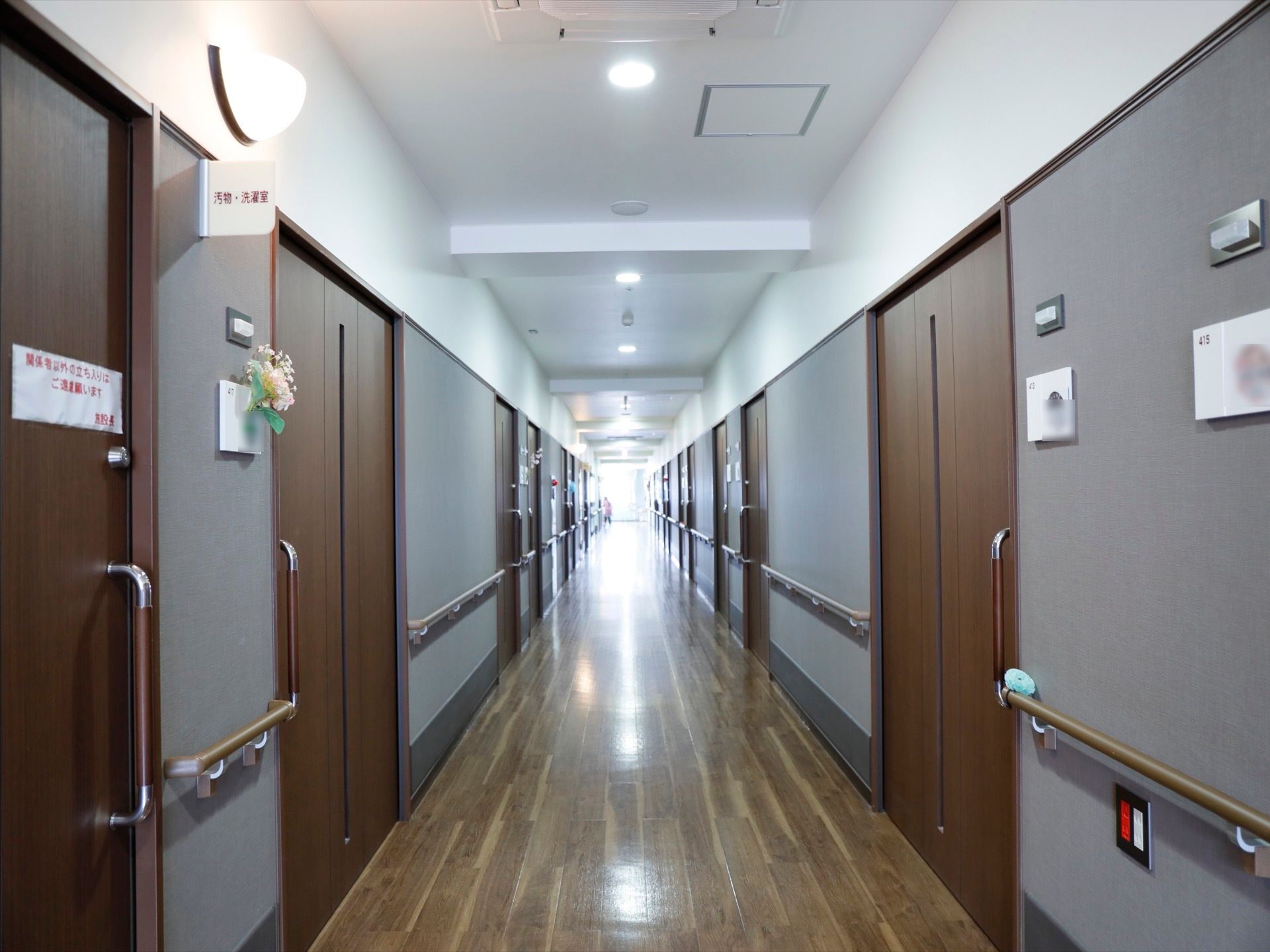 落ち着いた雰囲気の廊下に居室が並んでいる。扉は大きさのあるスライド式になっており、安全に開閉することができる。