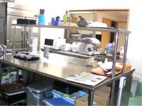 大型冷蔵庫や多くの調理器具を取り揃えた清潔感のある調理場