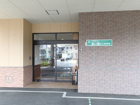 玄関は、少し奥まった位置にあり、ドアはガラスの自動ドア。ドアの横には「ケアホームアイアイ府中駅西」の看板が掲げてある。