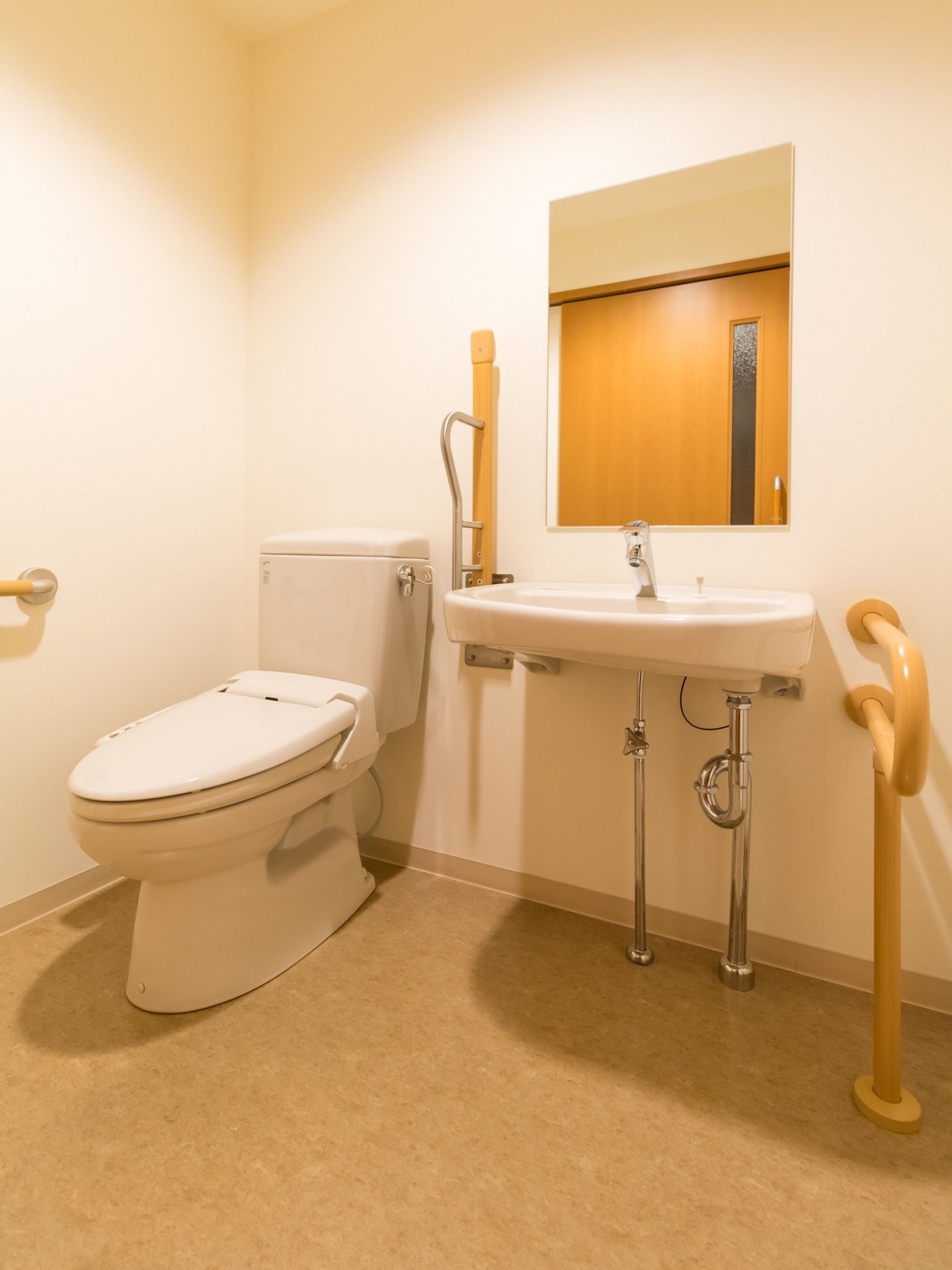 洋式トイレと手洗いを並べて設置している。手洗い前は車椅子でも使いやすいように、ゆったりとしたスペースを確保している。