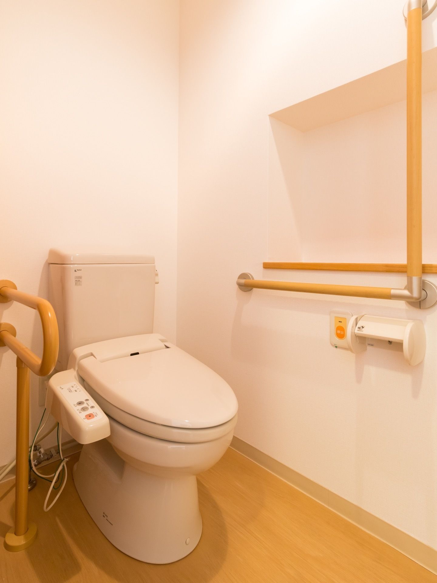 設置された洋式トイレの両側には手すりが設置されている。横の壁には緊急時呼び出しボタンが付いているので安心。