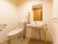 温水洗浄暖房便座が付いた洋式トイレと手洗いが並べて設置されている。周囲には高齢者でも安全に使えるように、複数の手すりが取り付けられている。