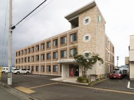 施設建物はレンガ調の外壁が素敵なマンションのような外観。建物前には複数台停められる駐車スペースが設けられている。