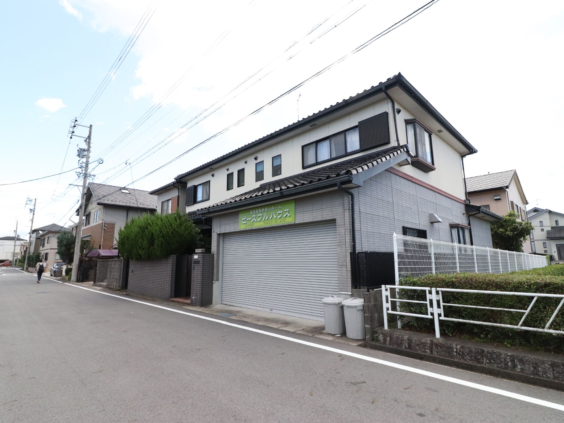 閑静な住宅街に建つ、普通の民家を改装した施設である。シャッター付きのスペースの隣に玄関出入口が設けられている。