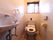 トイレには窓がある。設置された洋式トイレには温水洗浄機能が追加されている。壁にはトイレットペーパーホルダーとトイレの操作パネルが付いている。