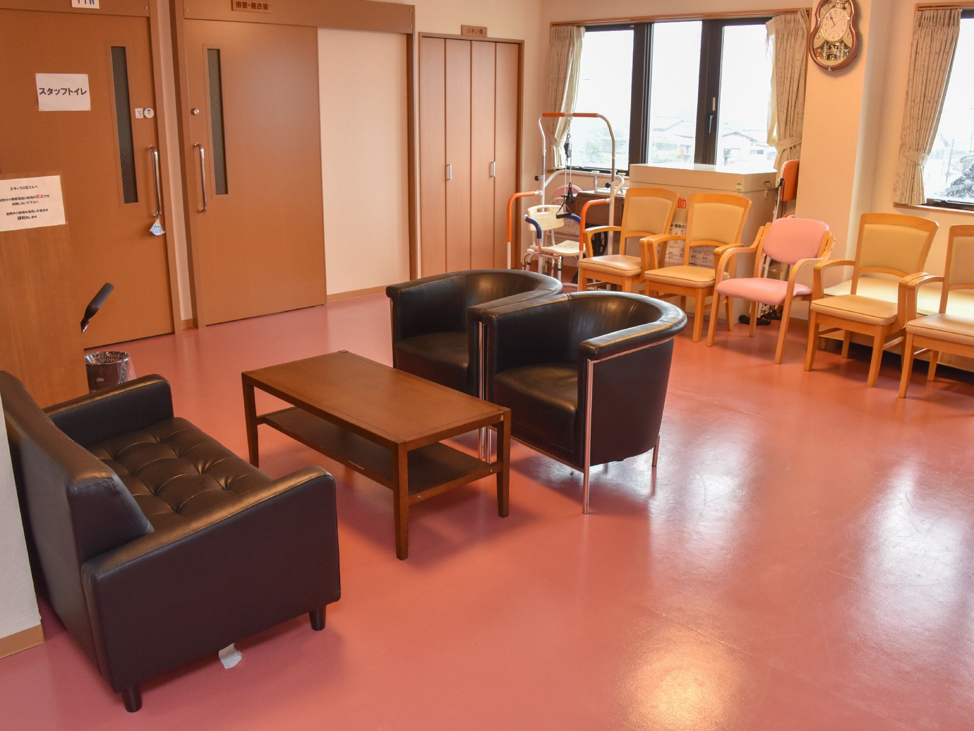 大広間には、黒い革張りの一人掛けソファや木の椅子などが並んでいる。隅のほうには、健康器具なども置いてある。