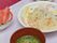 1人分の食事がセットされている様子である。汁物とフルーツを含めた4品が、白いトレーの上にきちんと並べられている。