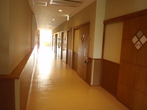 木の温もりが感じられる温かな雰囲気の廊下。道幅が広く利用しやすくなっている。居室のスライドドアが凝った造りになっている。