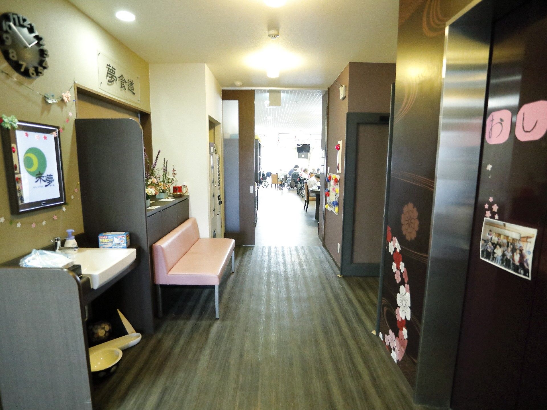 椅子でくつろぐ高齢者に微笑みかける女性スタッフ