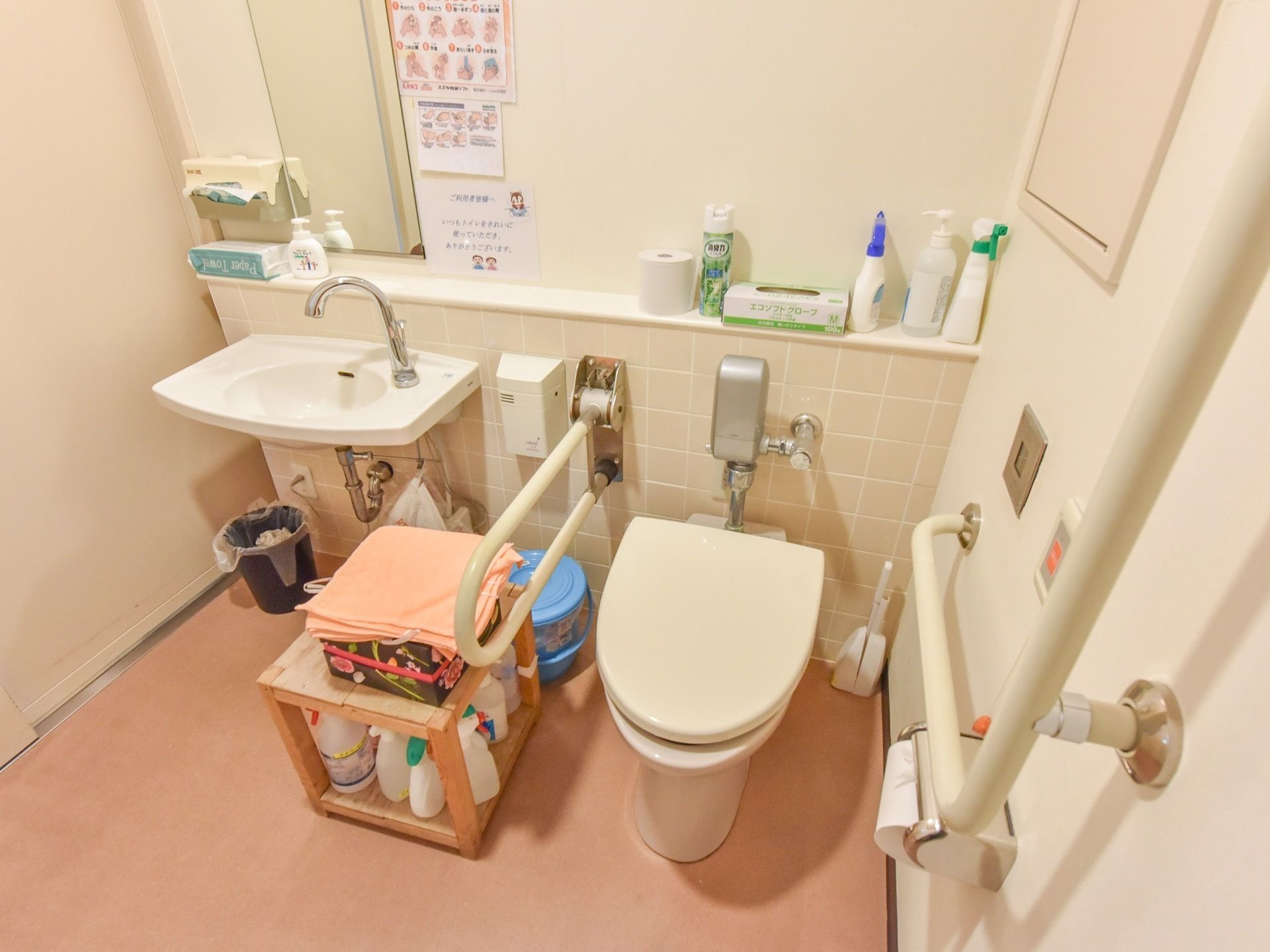手洗い場が併設された個室トイレ。壁には鏡が設置されており、横にペーパータオルがある。棚には消臭スプレーやハンドソープが準備されている。