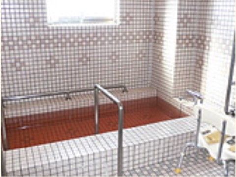 「よろこびの家 栄」の浴室。アルミの介助手すりにシャワーチェアと、補助設備が満載。