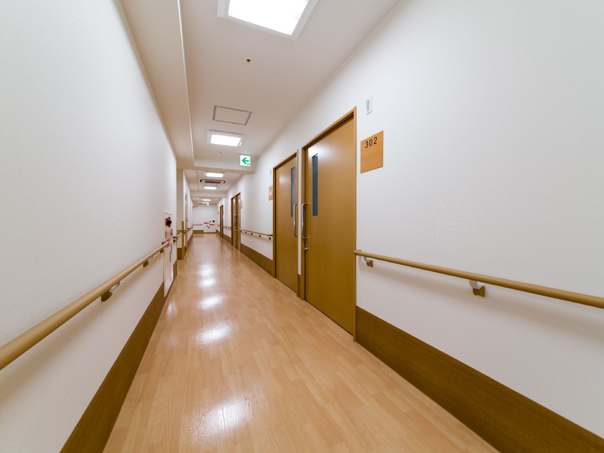 廊下の両サイドには手すりが設置されている。途中にはドアがいくつかあり、部屋番号を示す表札がかけられている。