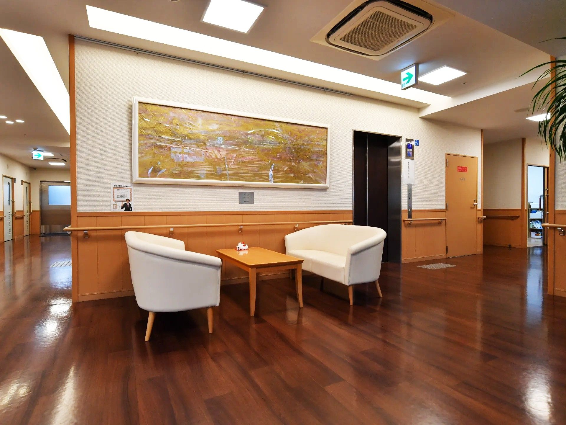 正面には1つのテーブルがあり、その両側にはソファが置かれている。右側にはエレベーターがある。周囲の壁には手すりが付いている。