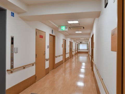 両壁に手すりが設置された広々とした印象の施設の廊下