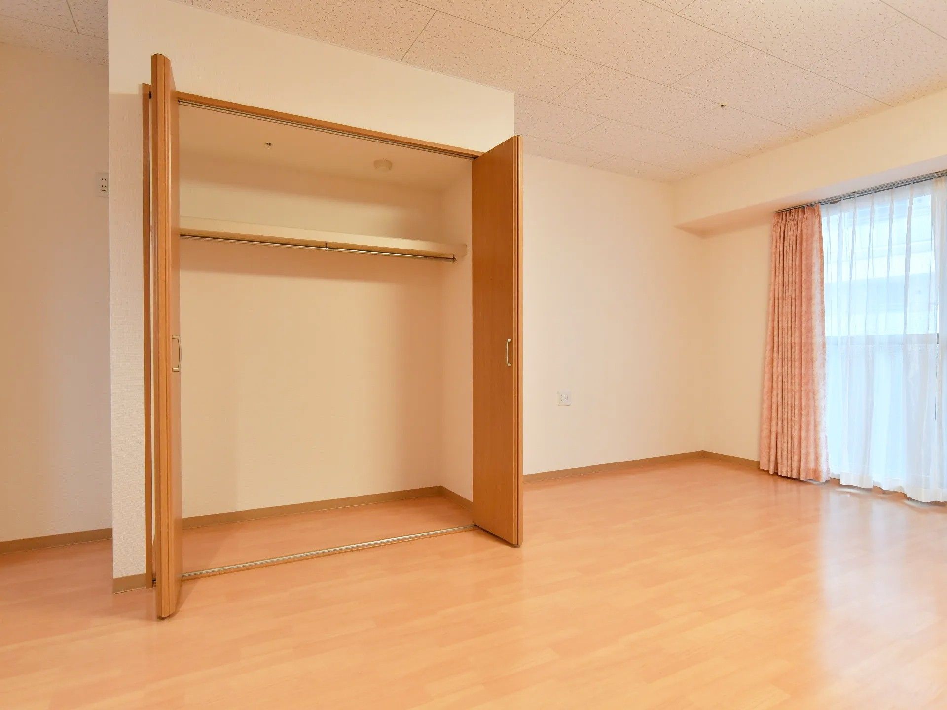 両開き扉が付いた収納スペースが正面にある。中は2段に区切られている。上側に板が1枚渡っており、その下には棒が1本付いている。