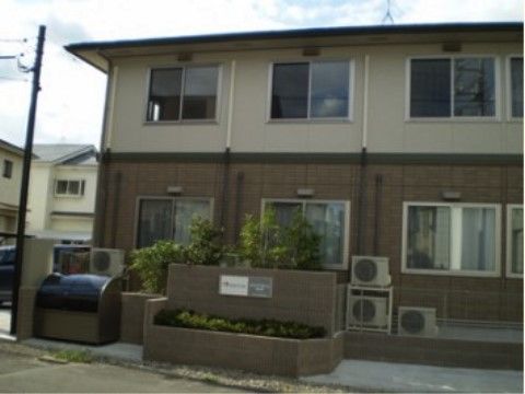 鉄骨造で、温かみのある印象の二階建ての施設建物外観