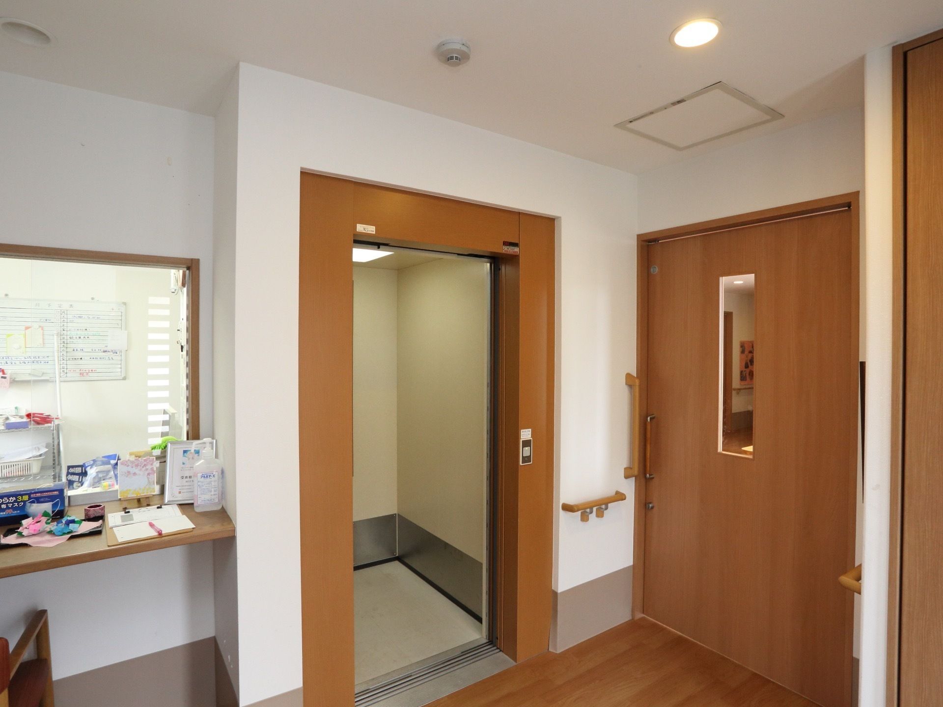 エレベーターの枠は、建物内の建具と統一された木製で、落ち着きのある雰囲気である。１階と２階を行き来するシンプルなエレベーターである。