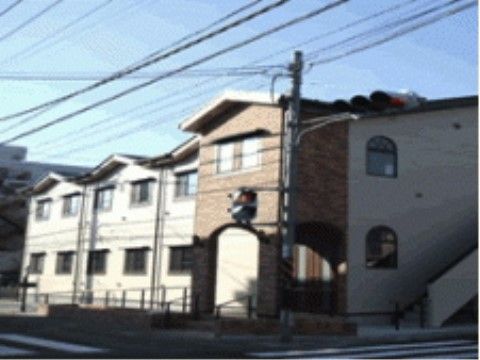 開放的な窓が多く付いている、ブラウン調の外壁の施設建物