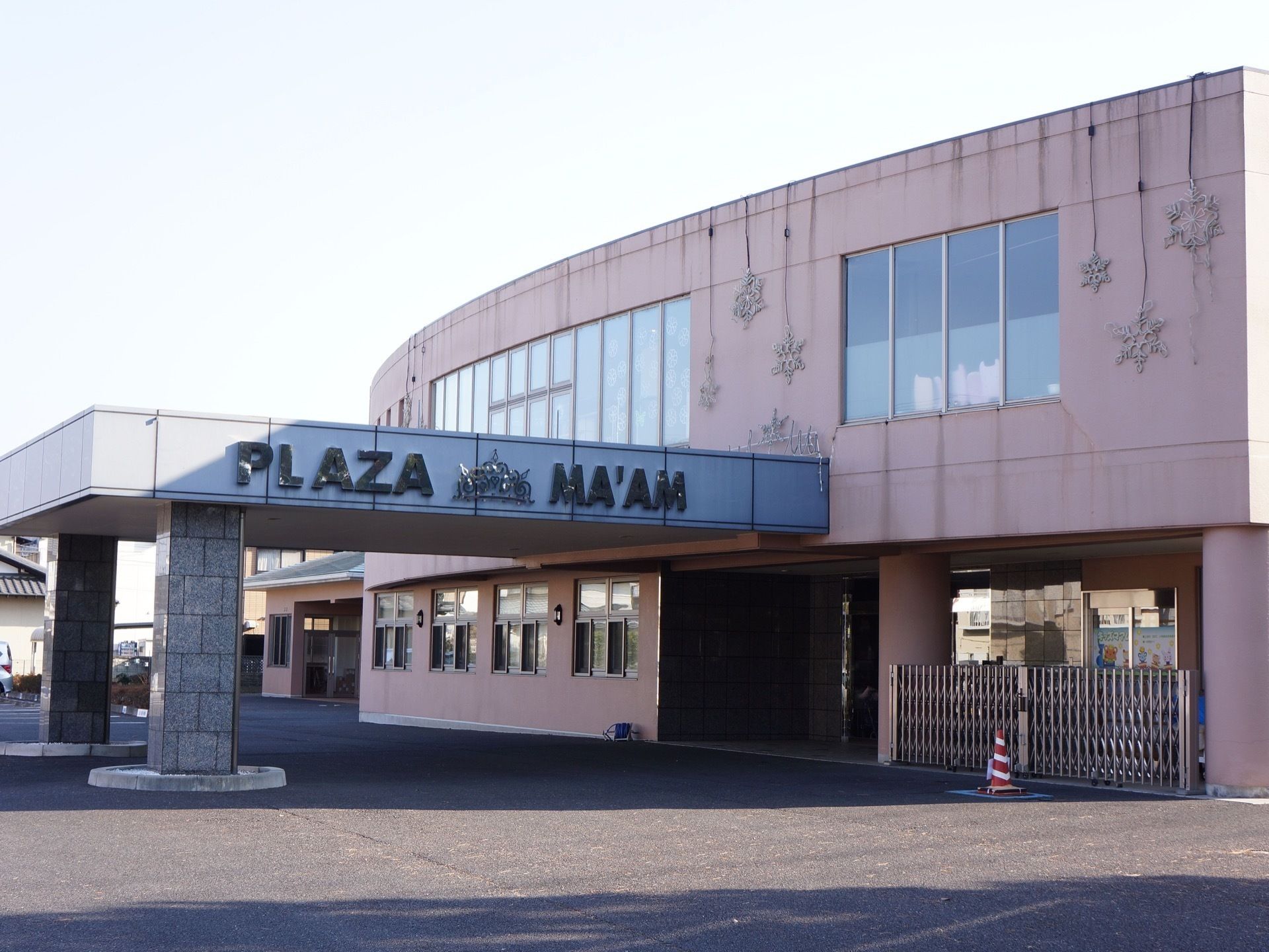 外壁には雪の結晶を模した装飾品が飾り付けられている。エントランスは広々としており、ひさしが設置されている。