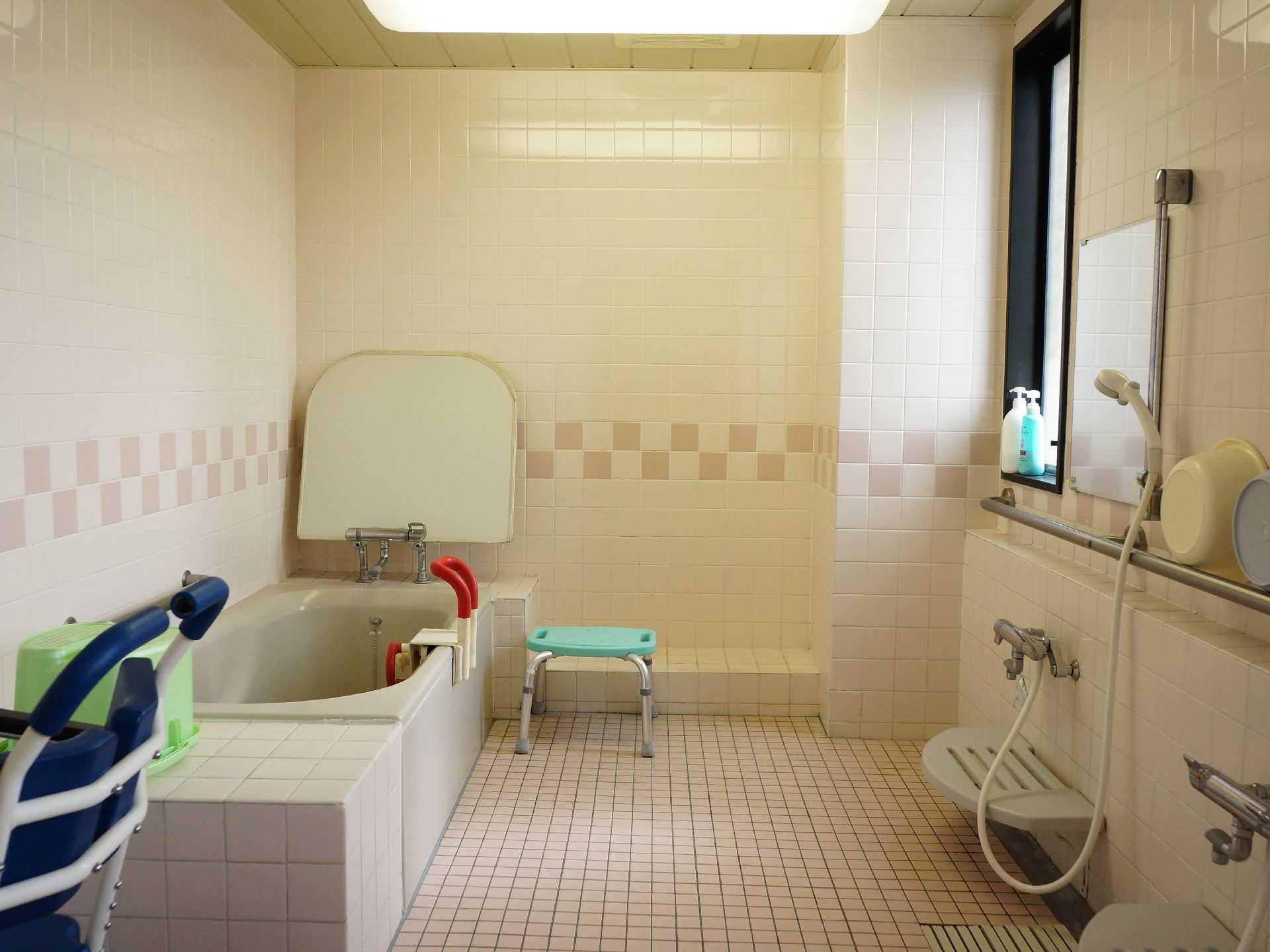 浴室の右側の壁には長方形の窓があり、日差しが射し込んでいる。天井には大きな照明があり、明るさが確保されている。