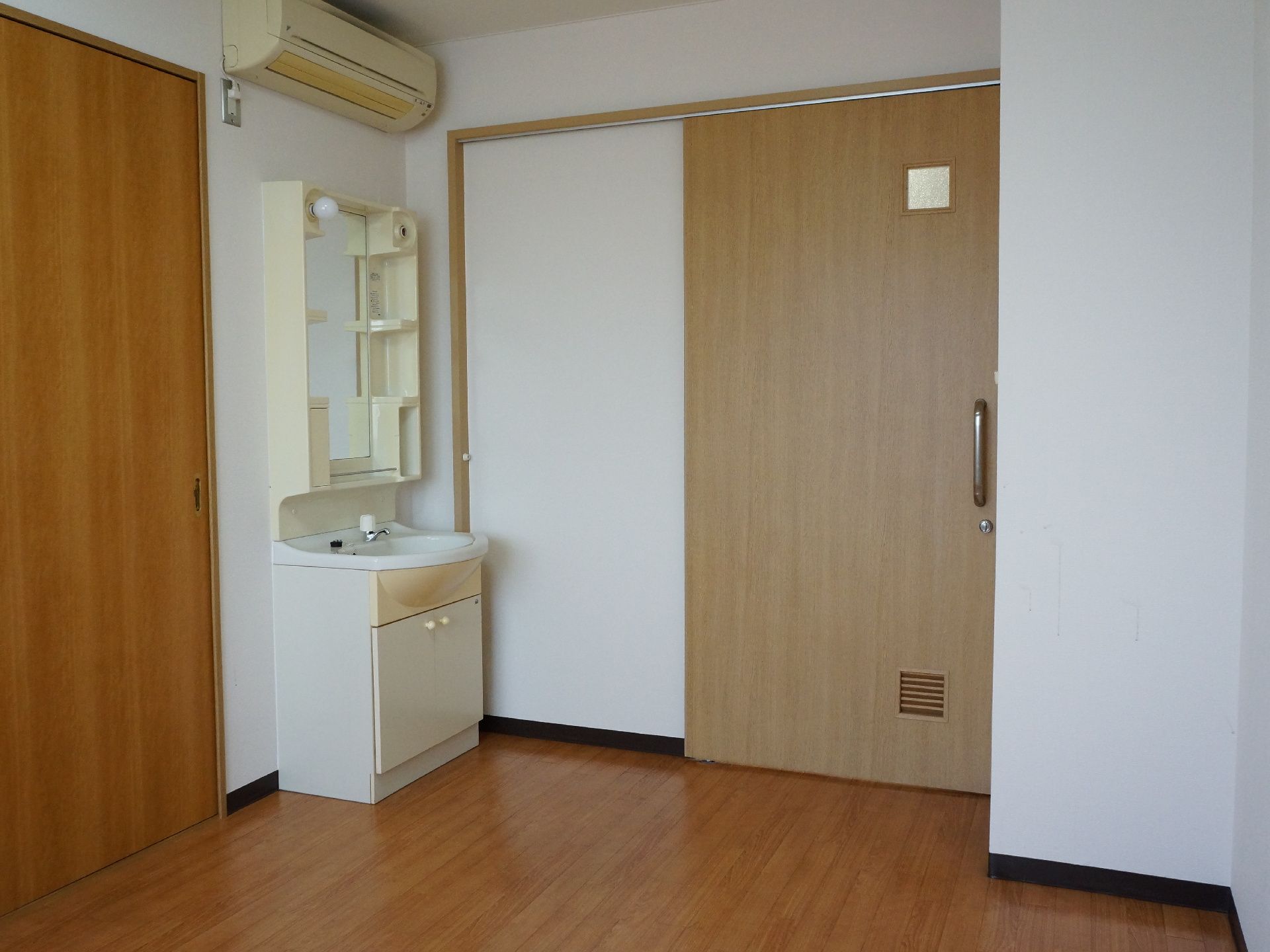 居室の入り口は木製の引き戸で、上部には四角い小窓が設けられている。内部には左側に化粧洗面台が設置されている。