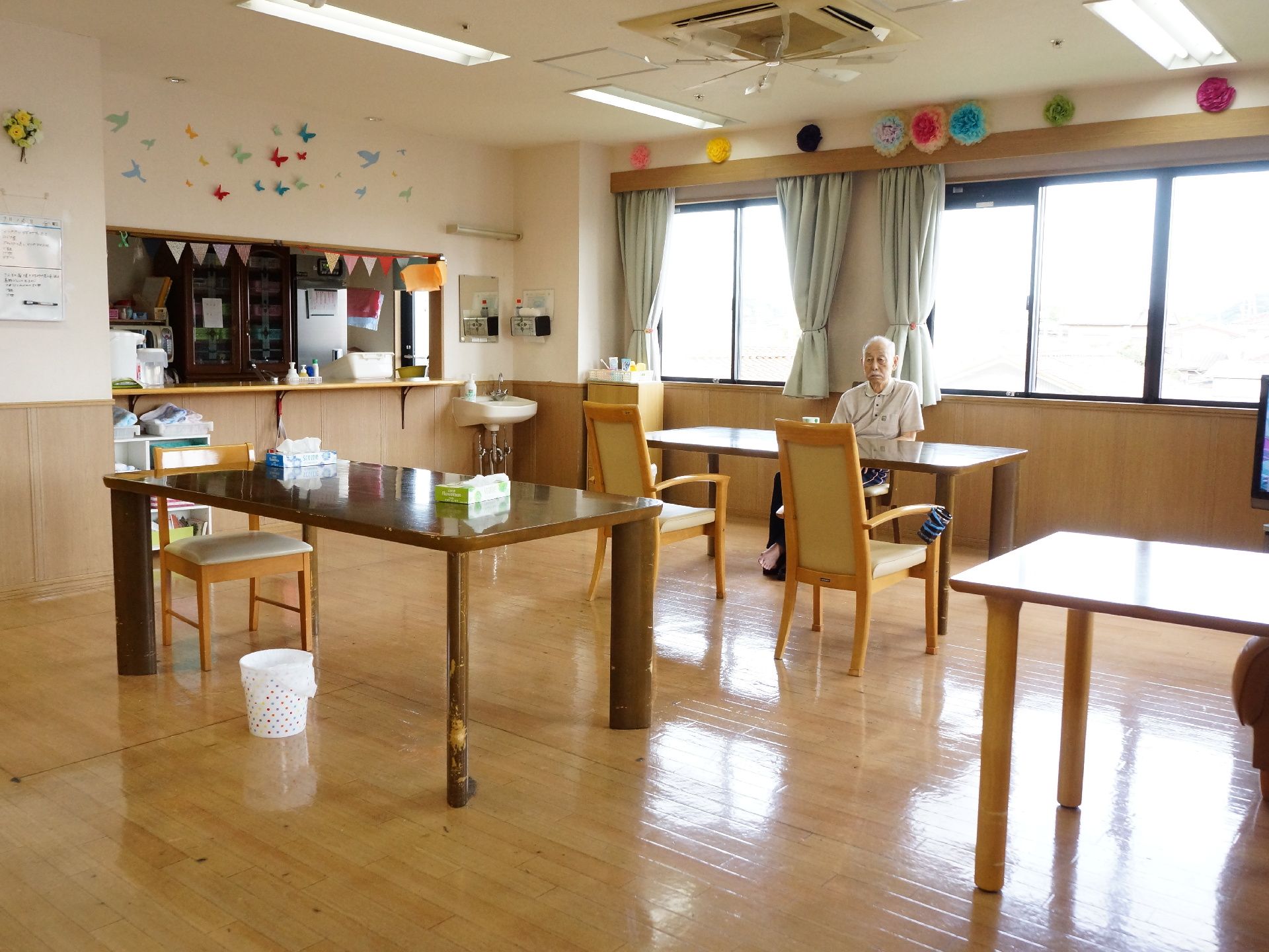 共有スペースの左側にはカウンターがあり、上部の窓からはキッチンの内部が見えている。右側に洗面台が設置されている。