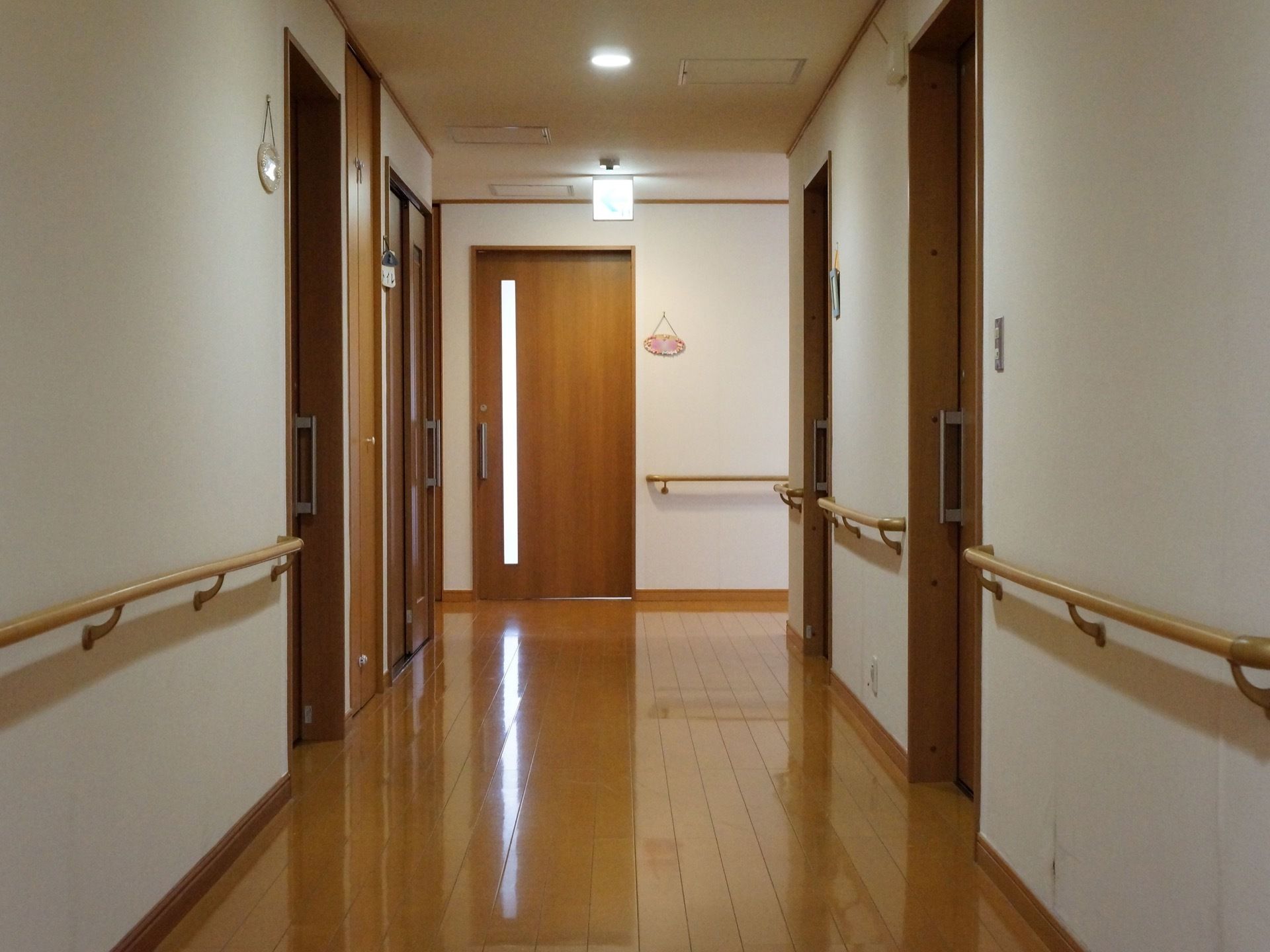 居室の近くにはプレートが設置されており、誰の部屋かわかりやすくなっている。天井には非常口の位置を示す標識がある。