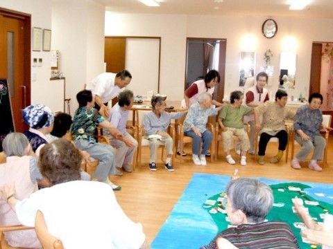 円になって椅子に座りレクリエーションを楽しむ高齢者