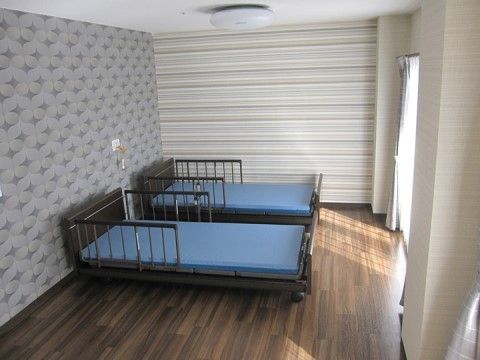 日光が差し込む大きな窓と、介護用ベッドが二台置かれている個室の部屋