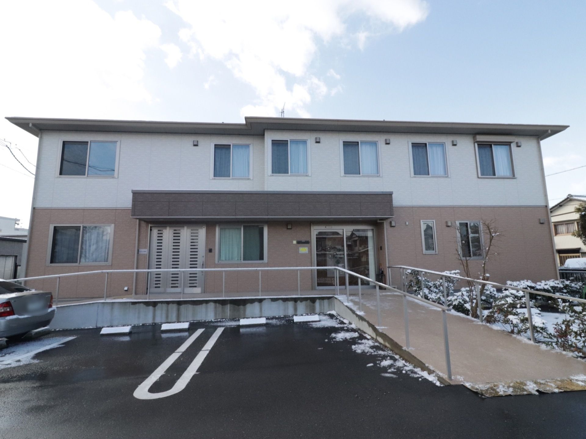 2階建て施設建物を正面から見た様子である。入居者様の立場を考えて、2か所に玄関スロープを設けている。