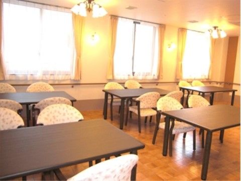 肘掛椅子とテーブルのセットが均一に並んでいるダイニングルーム