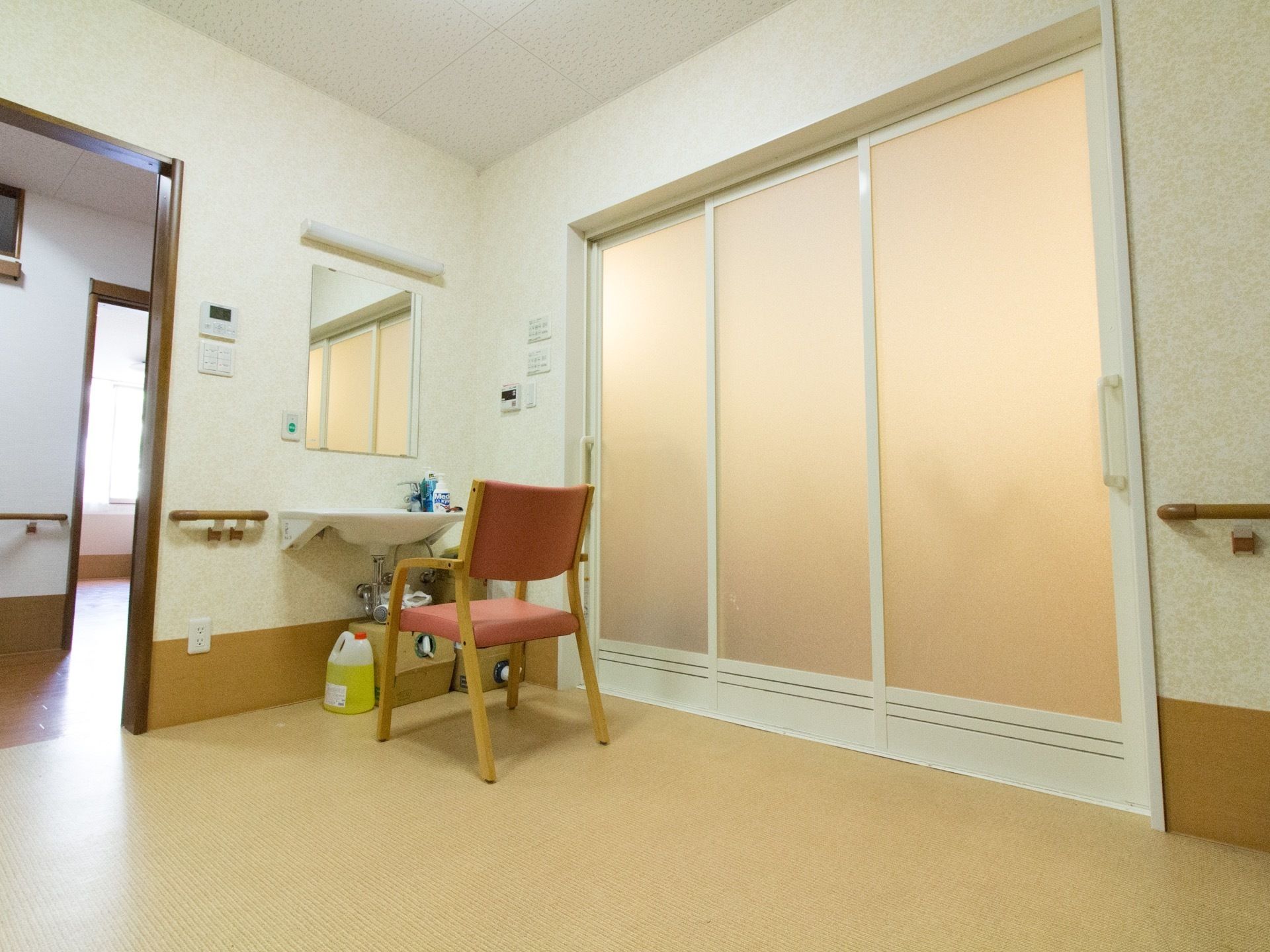 脱衣所は物も少なく広々としているので、介助者と一緒でも窮屈さを感じることはない。椅子に座って身支度ができるので、入居者様の負担は少ない。