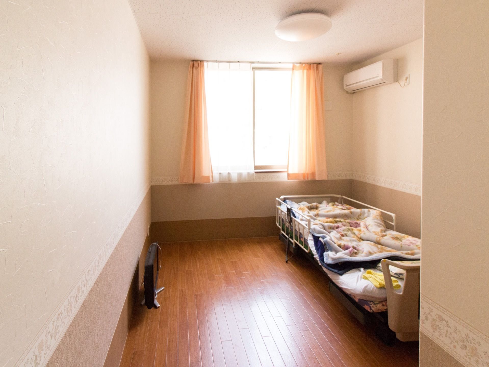 居室は日当たりが良く、居心地の良い雰囲気。ベッドはクローゼット側に寄せてあるので、反対側は通路として広くスペースが空いている。