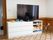 中央にはテレビがある。その下には白色の収納棚があり、そこの右側には人形やボードゲームなどが片付けられている。