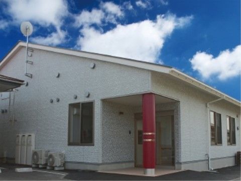 赤い玄関ポーチ柱が印象的な、三角屋根で白い壁の平屋ホーム