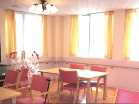 壁に沿った形で手すりが付いた、テーブルと赤い肘掛椅子の並ぶ食堂