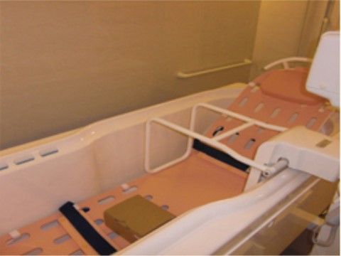 浴室には長くて広い浴槽があり、黒いベルトが2本取りつけられている。浴槽と壁には、手すりが設けられている。