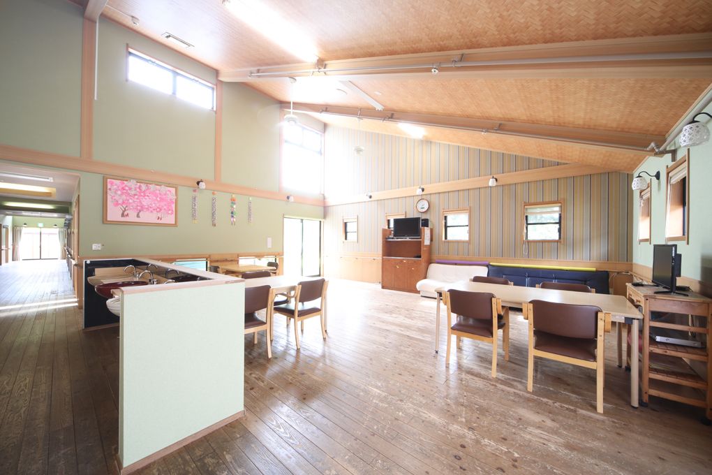 車椅子で外出する高齢女性と隣りに寄り添う女性ヘルパー