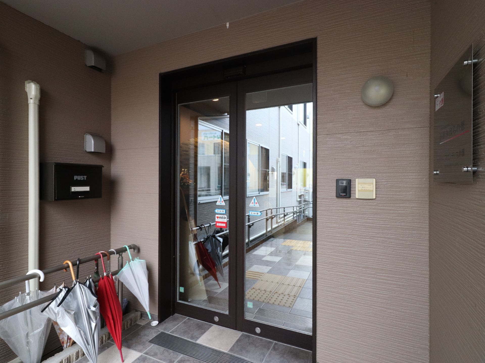 エントランスの壁にはインターホンがあり、郵便受けが備え付けられている。また玄関の扉は自動ドアとなっている。