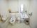 洗面台が併設されたトイレである。壁には手すり、緊急呼び出しボタンが備え付けられており、花が飾られている。