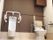 トイレには便座と小便器が間隔を置いて並んでおり、どちらも両サイドに手すりが設置されている。床はベージュで壁は白と茶色のツートンカラーである。