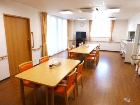入居者様同士が利用する共有スペースはとても広々としている。テーブルと椅子の他にもテレビも設置してある。