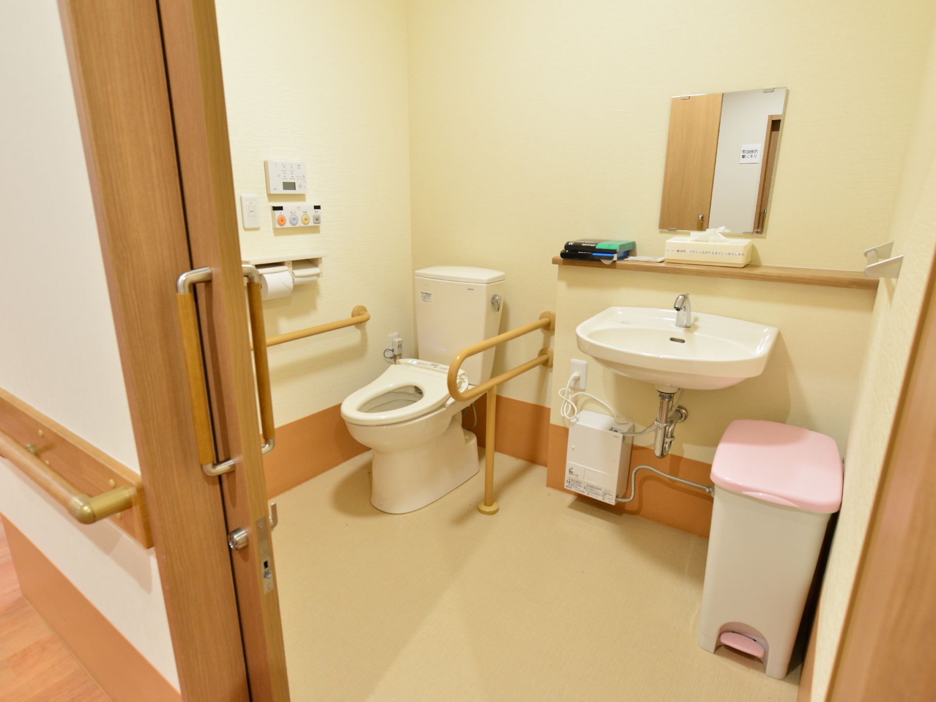 トイレは整頓され、とてもきれいに保たれている。立ち上がる際に助かる手すりや、手洗い場を完備している。明るい照明で清潔感があふれる。
